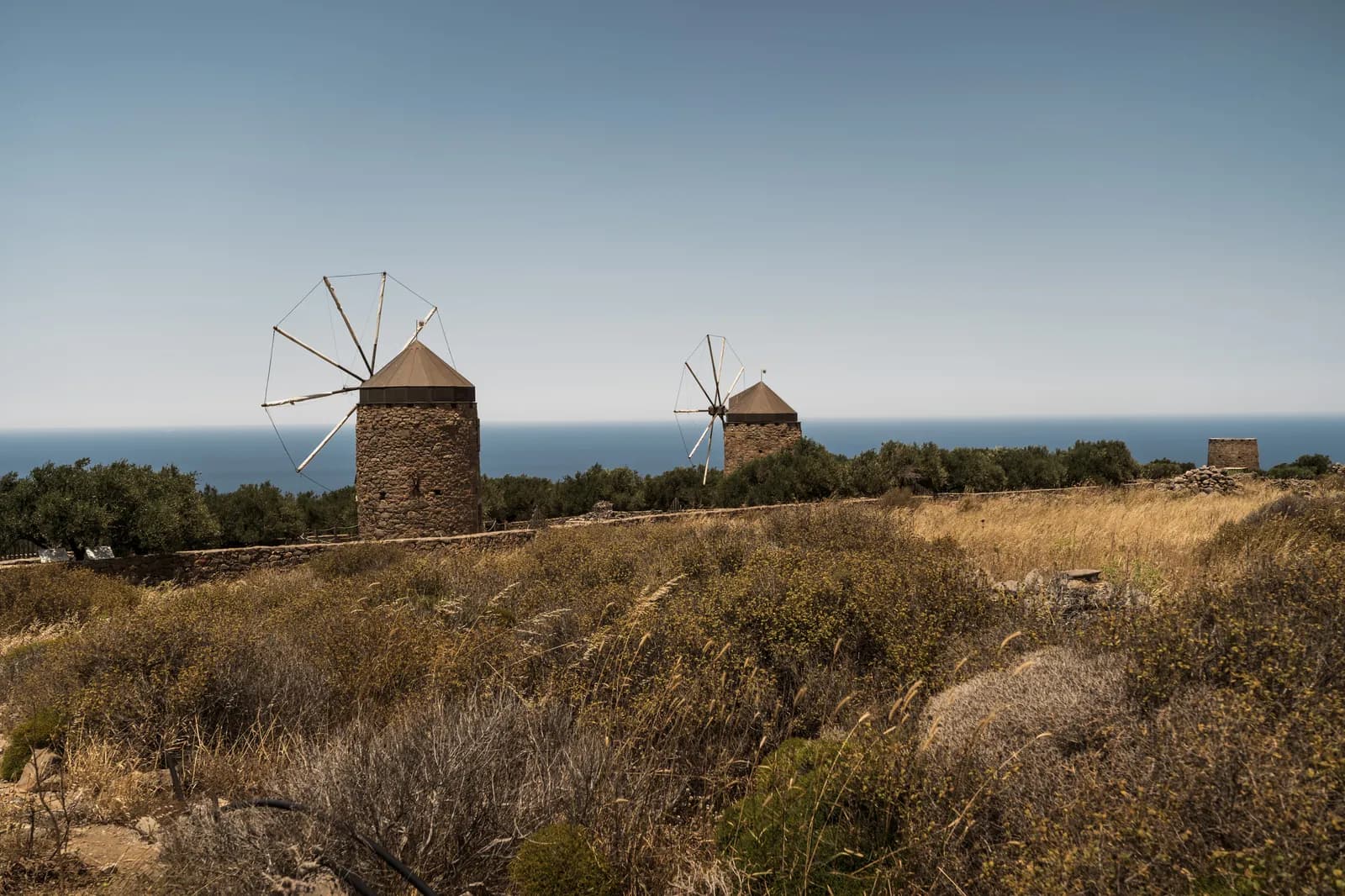 Moulins à vent de pierre restaurés au milieu de la garrigue, au-dessus de la mer près de Vrouchas