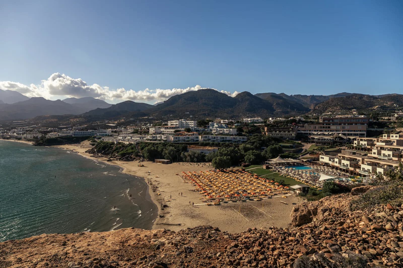 Baie de sable du sud-est de la Crète sous un ciel changeant, nuages accrochés aux montagnes