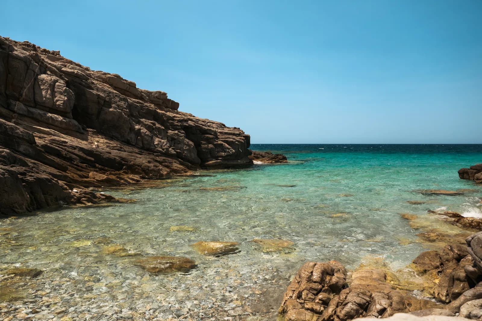 Crique rocheuse déserte à l'eau transparente sur la côte au nord de Plaka