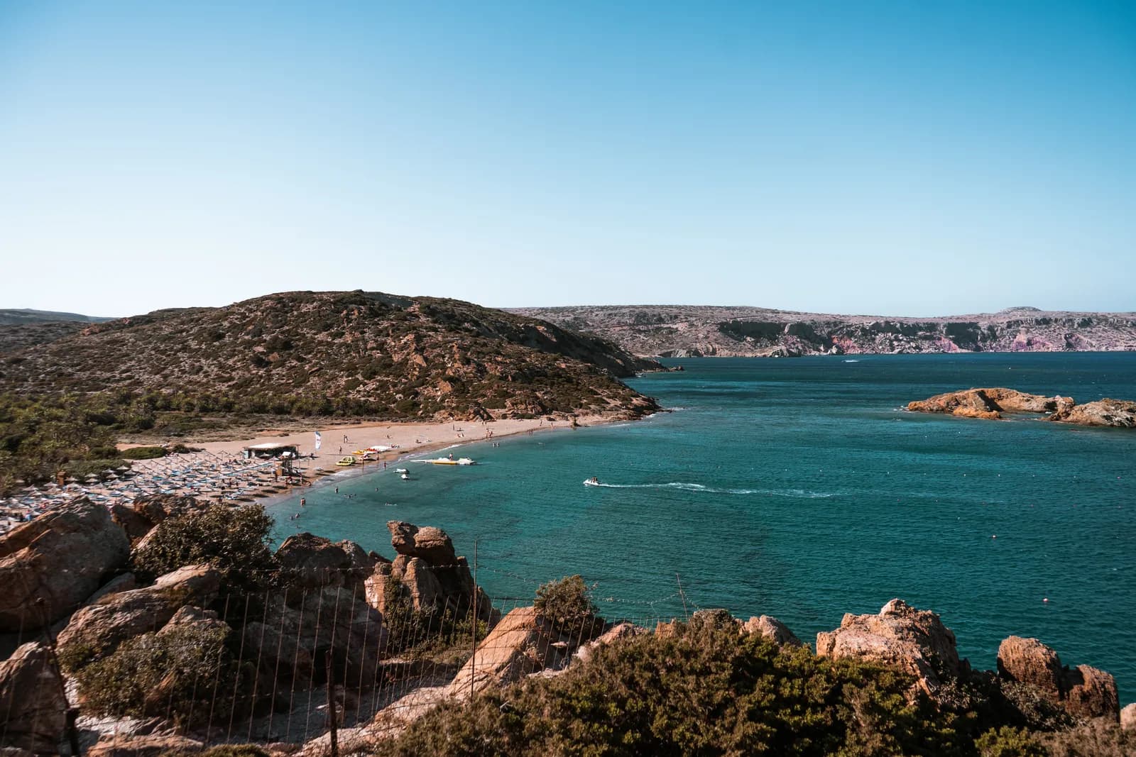 La baie de Vai vue des rochers rouges, sa plage de sable et son eau turquoise face aux îlots