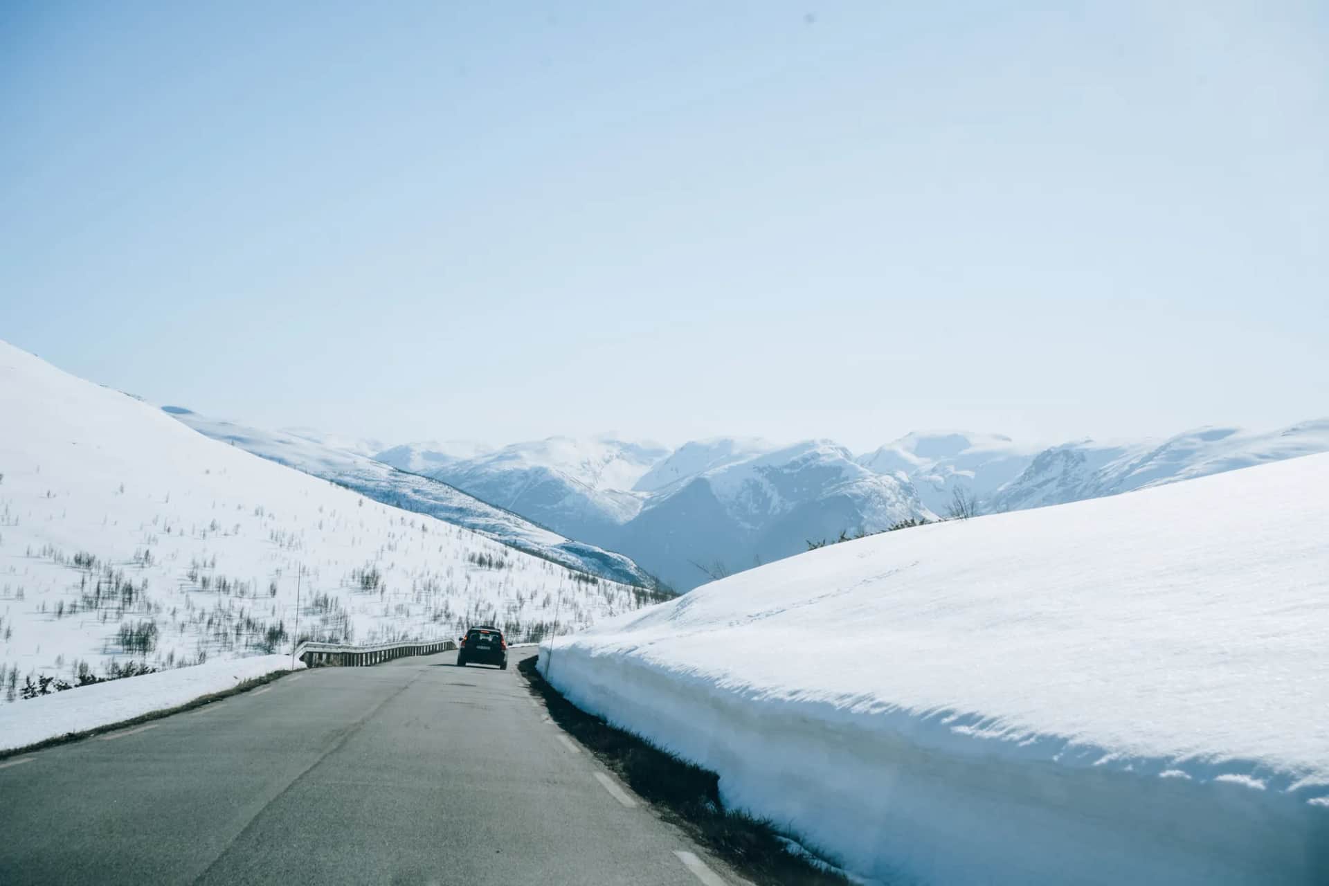Route de montagne bordée de murs de neige dans la région de Flåm, début mai