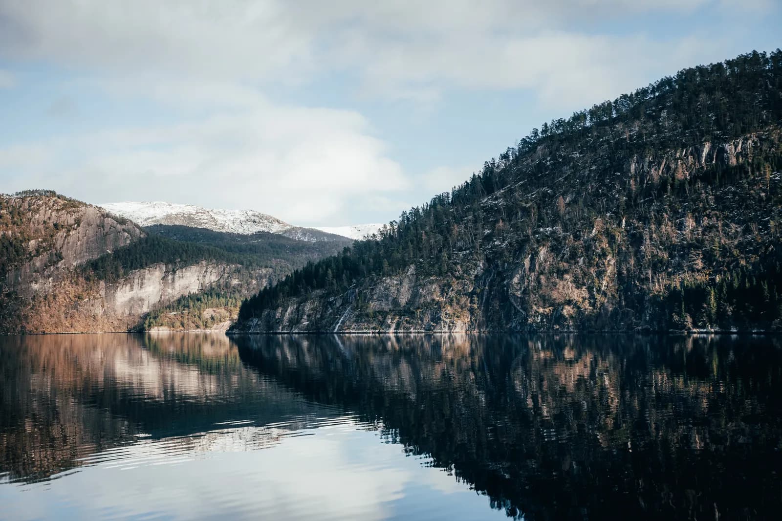 montagnes se reflétant dans l’eau calme du fjord, près de Mostraumen