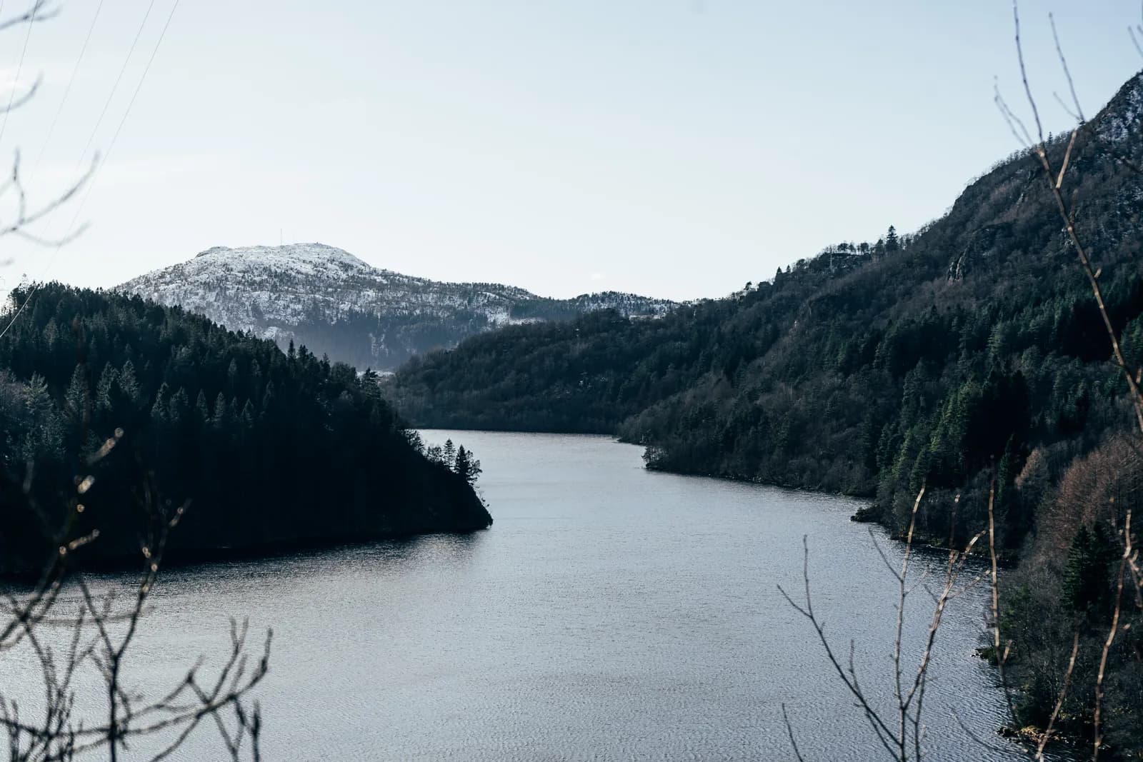 Le lac-réservoir de Svartediket entre des montagnes boisées, le 25 février 2023