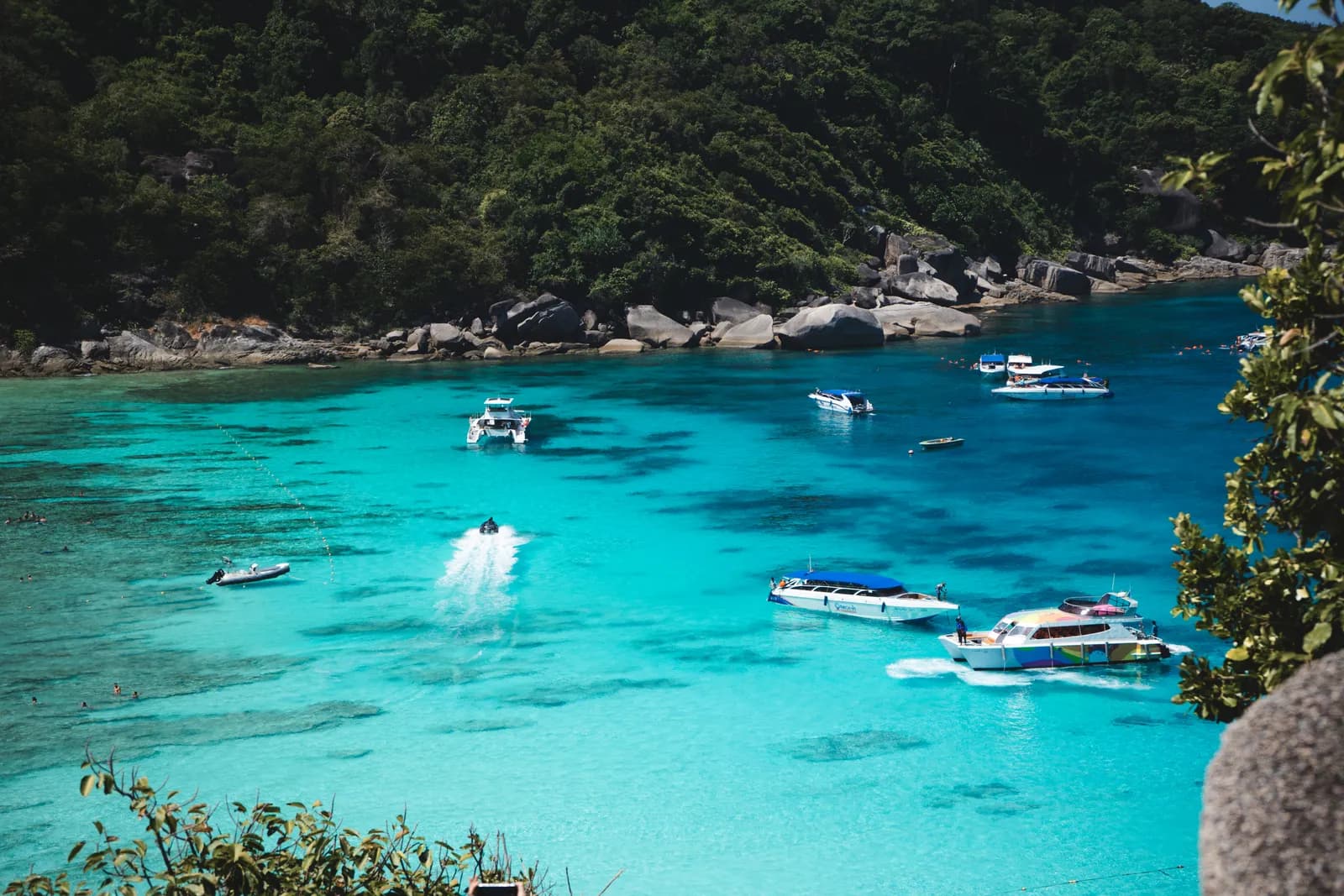 Eau turquoise et speedboats au mouillage dans une baie des îles Similan, en mars