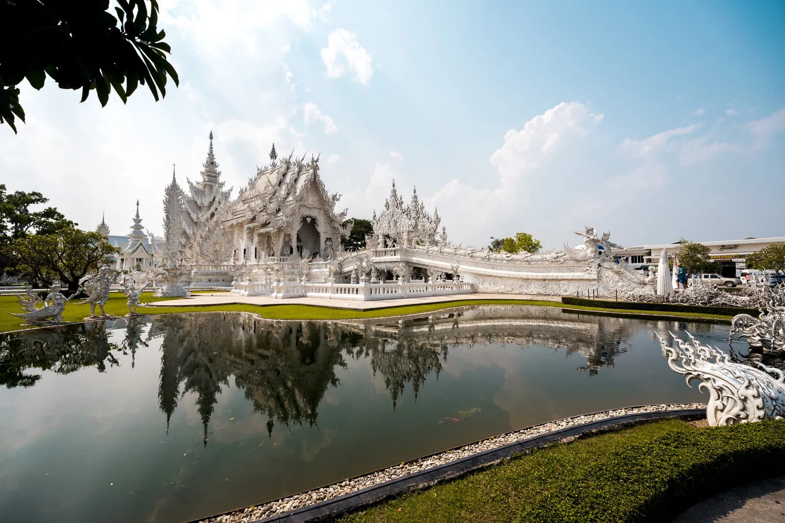 Le temple blanc Wat Rong Khun et son reflet dans le bassin, à Chiang Rai