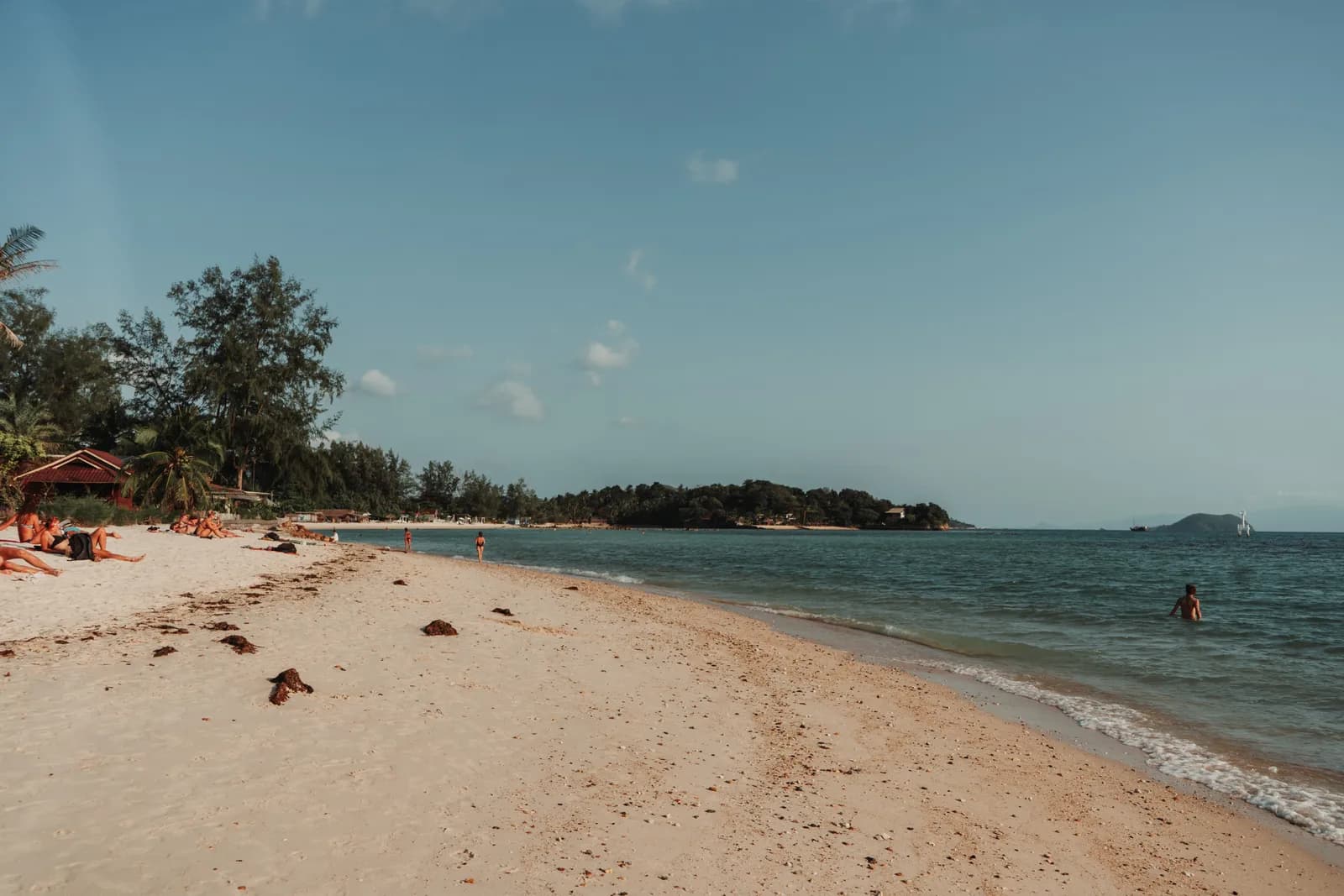 Plage dorée et îlot boisé sur une mer calme, côté Srithanu, à l'ouest de Koh Phangan