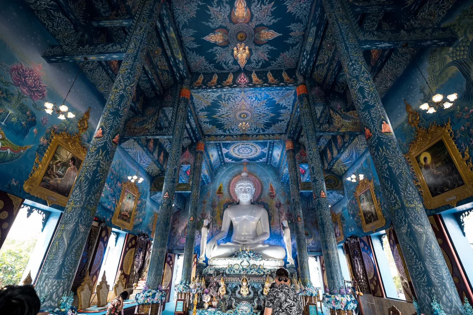 Intérieur bleu nuit et or du temple bleu Wat Rong Suea Ten, autour d'un Bouddha blanc, à Chiang Rai
