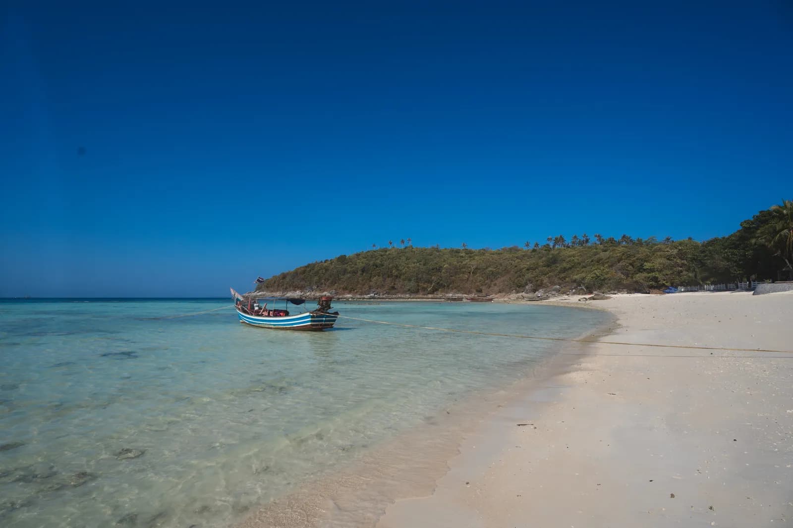 Bateau long-tail sur l'eau transparente d'une plage de sable blanc de Koh Racha, au sud de Phuket