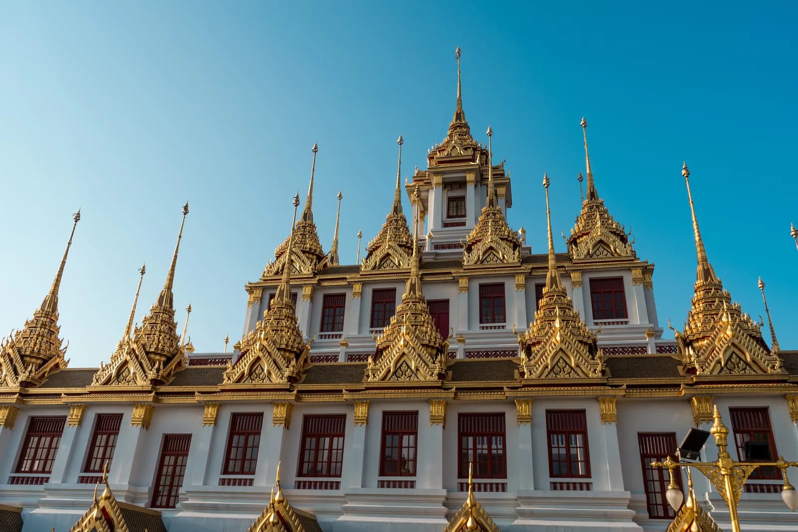 Flèches dorées du Loha Prasat de Wat Ratchanatdaram sous un ciel bleu, à Bangkok