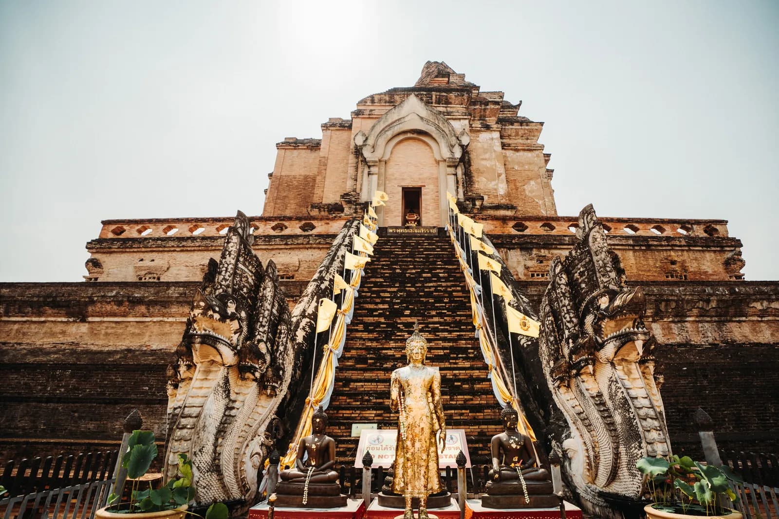 Escalier gardé par deux nagas sur la face est du grand chedi de Wat Chedi Luang, avec un Bouddha debout doré