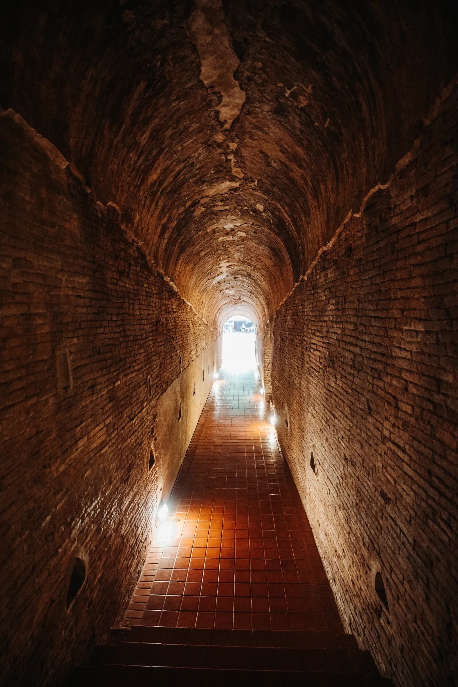 Long couloir en briques des tunnels de Wat Umong ouvert sur la lumière du jour, à Chiang Mai