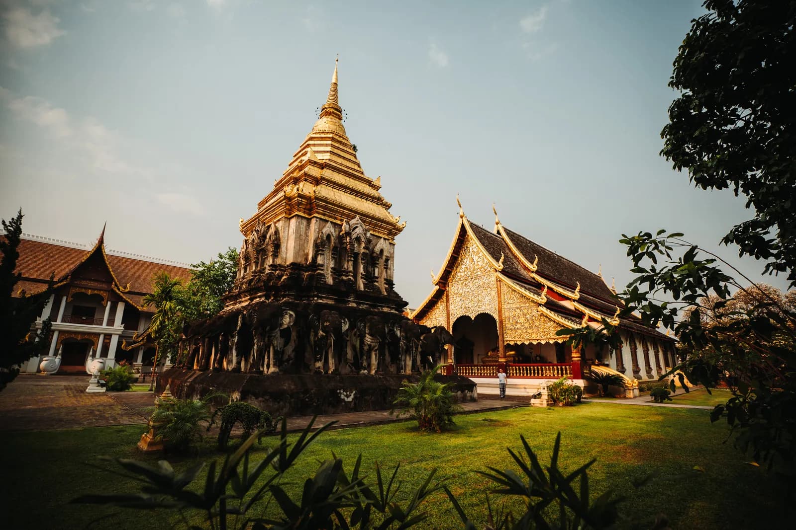 Chedi Chang Lom porté par des éléphants et vihan doré de Wat Chiang Man, au milieu des pelouses