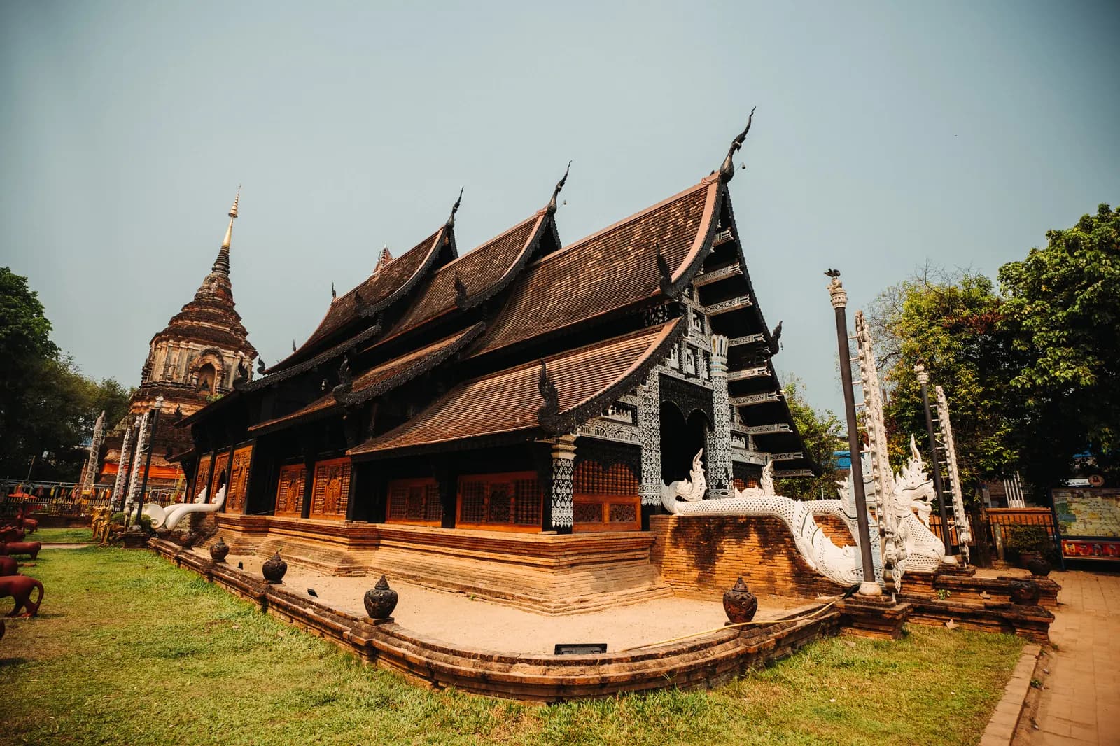 Vihan en teck sombre aux toits étagés et grand chedi de briques nues de Wat Lok Moli, au nord des douves