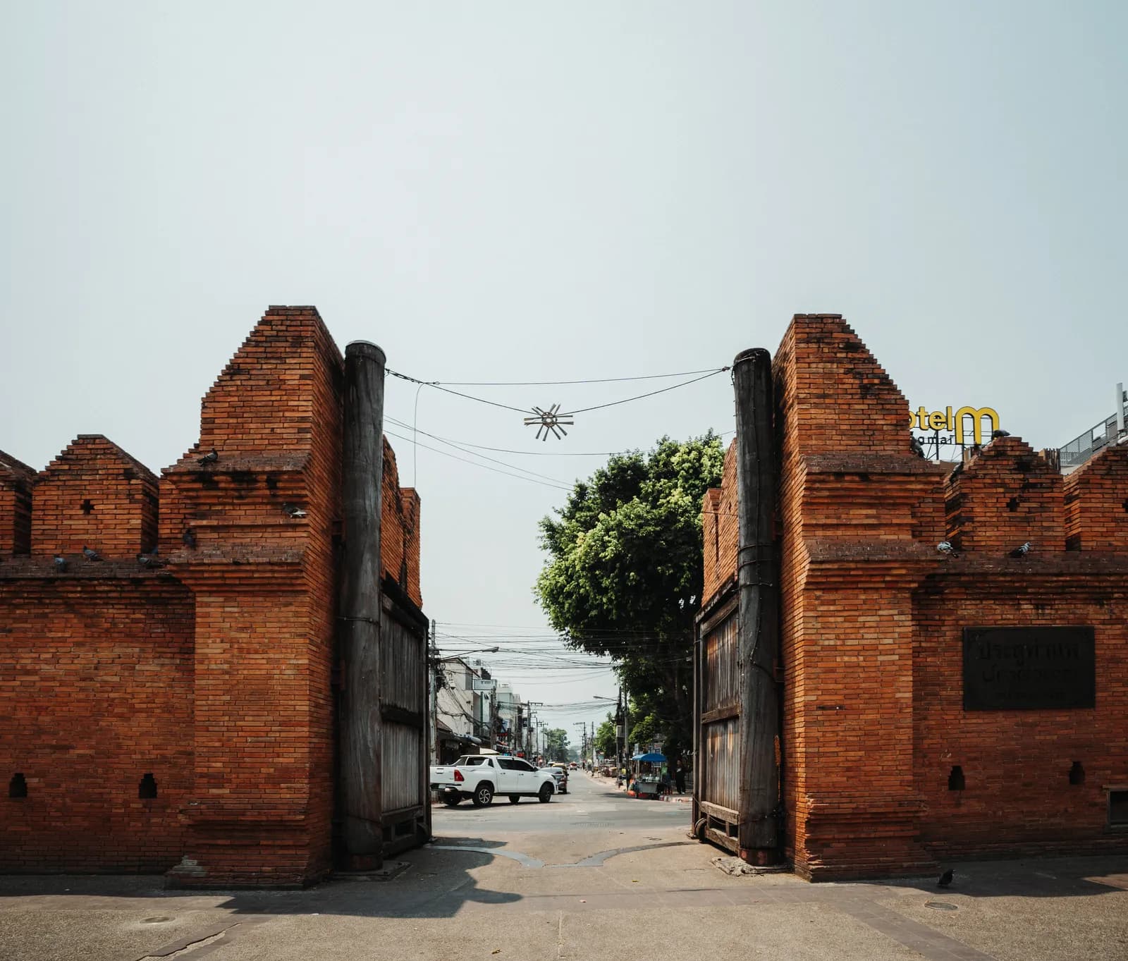 Porte Tha Phae et remparts de briques rouges à l'est de la vieille ville de Chiang Mai, sous un ciel voilé