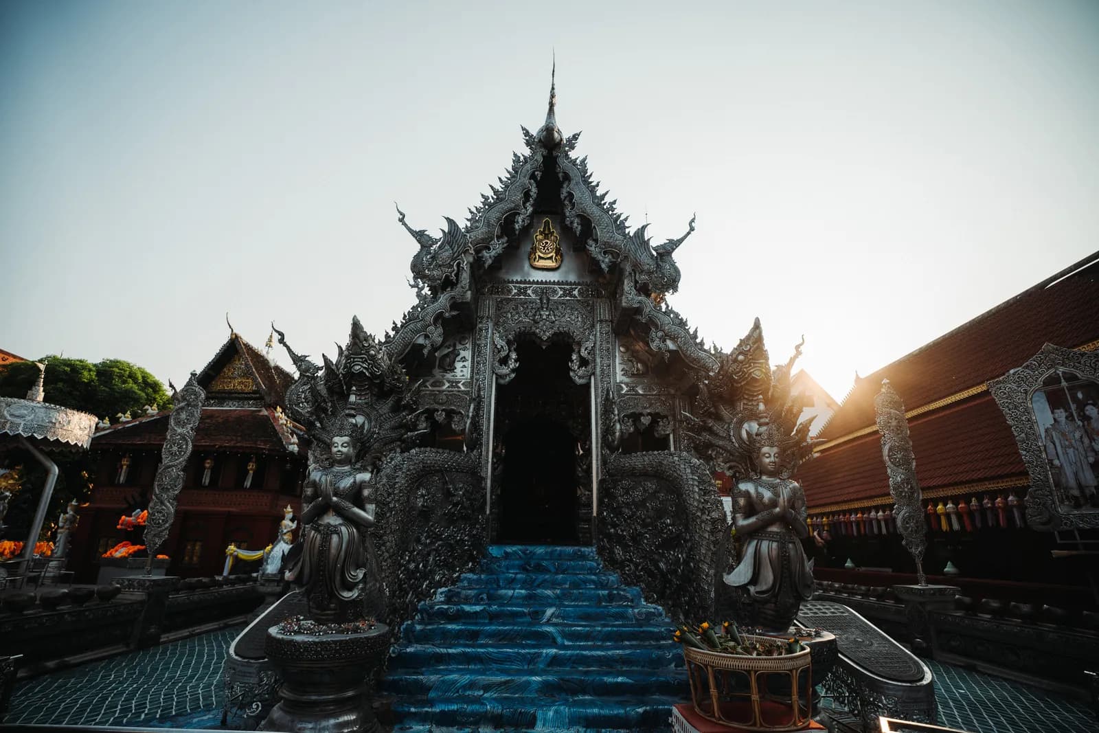 Ubosot d'argent de Wat Sri Suphan au soleil couchant, escalier bleu gardé par deux divinités argentées
