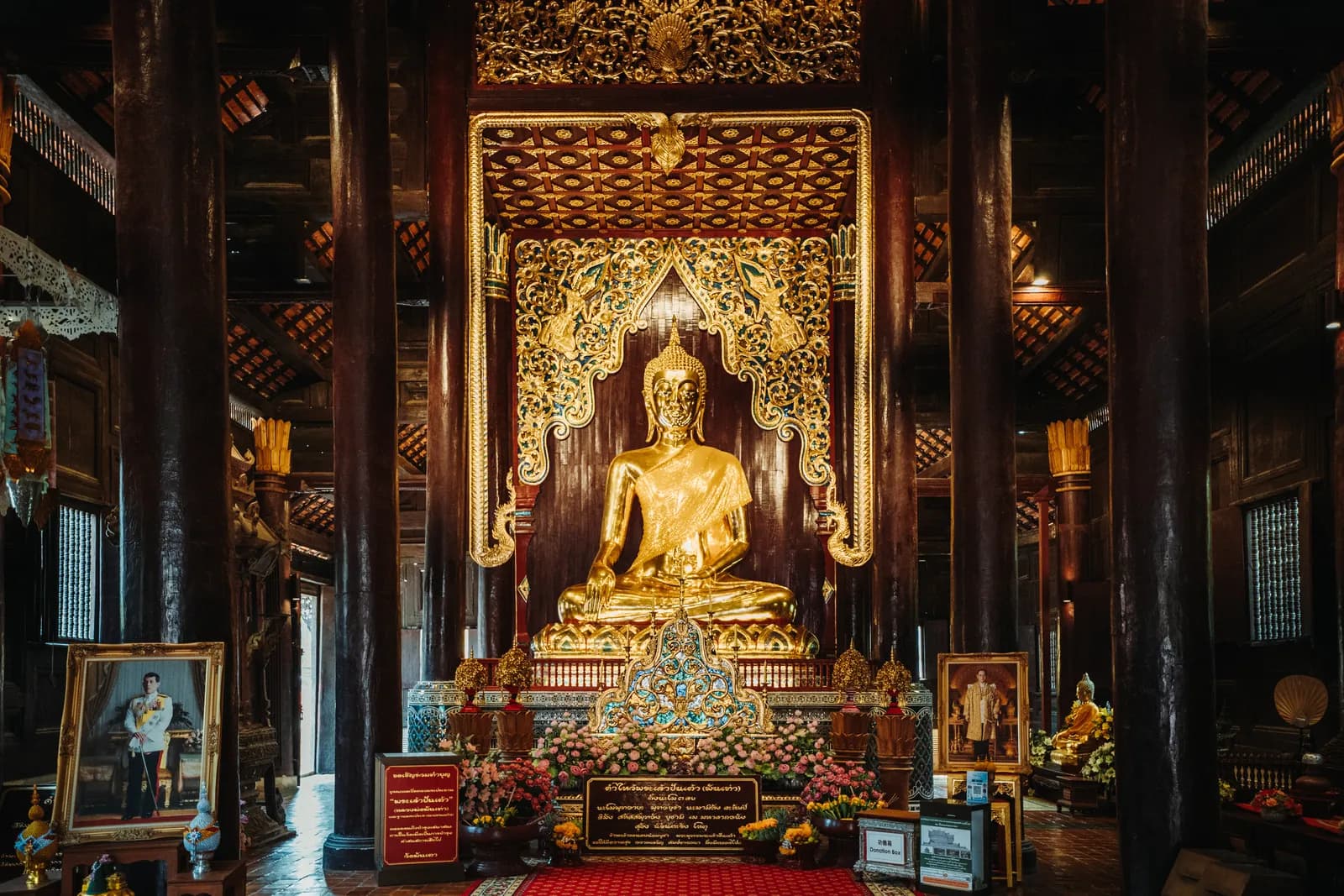 Bouddha doré au fond de la salle en teck à piliers de Wat Phan Tao, ancienne résidence royale