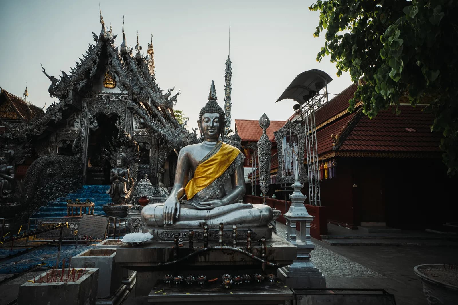 Grand Bouddha argenté drapé de jaune devant l'ubosot d'argent de Wat Sri Suphan, dans le quartier de Wualai