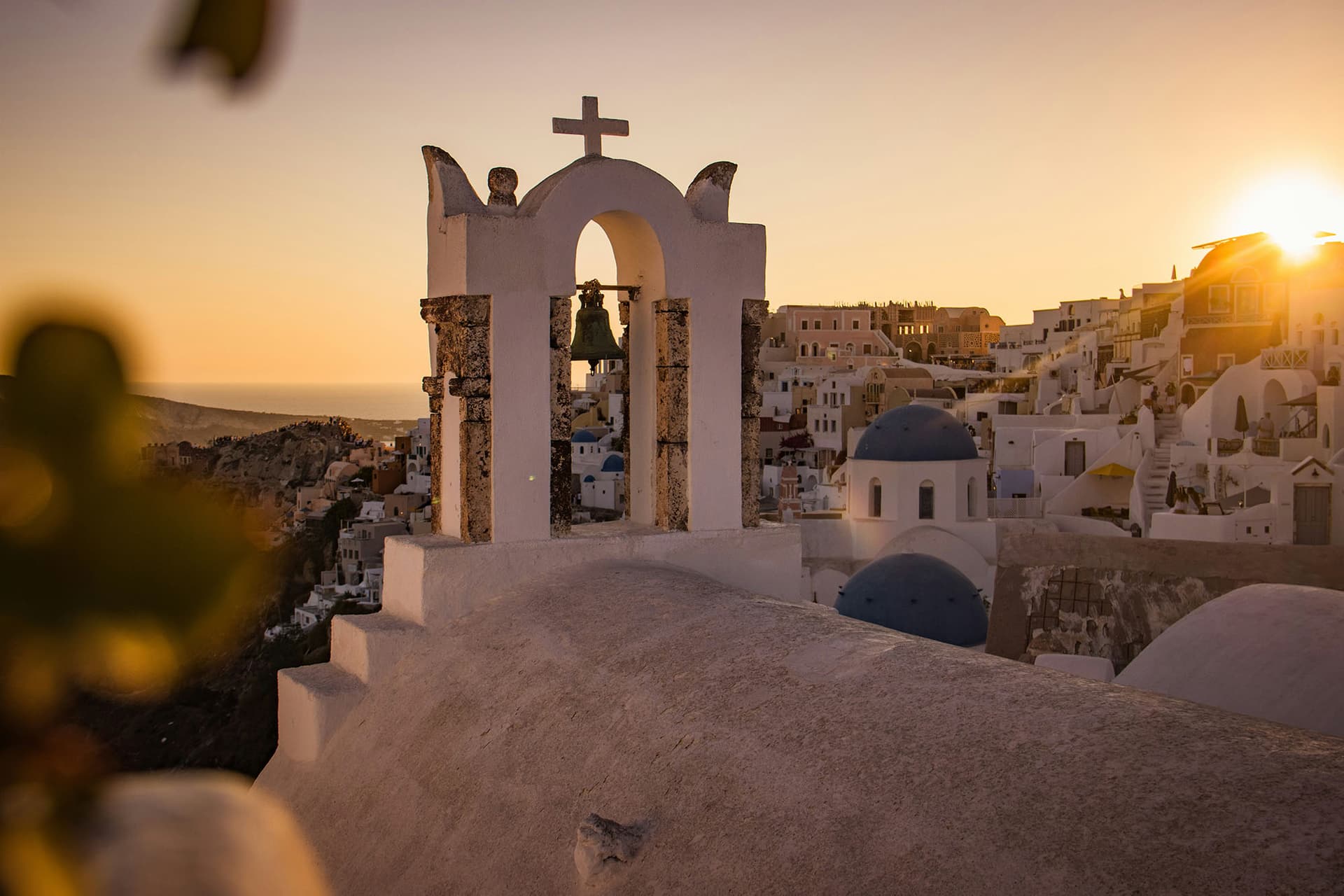 Golden sunset light illuminating the whitewashed houses of Oia in Santorini