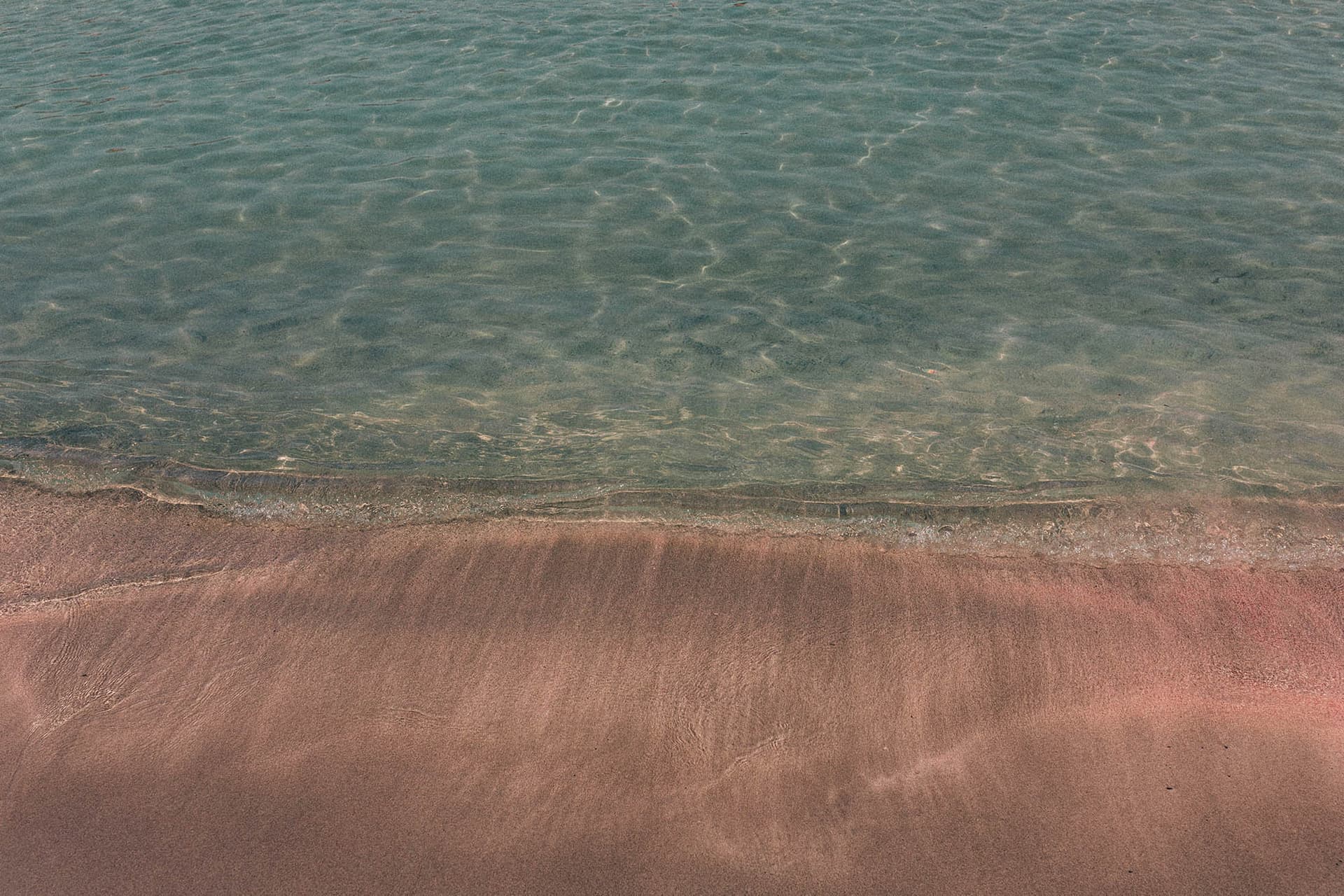 Close-up of Elafonisi sand showing the subtle pink hues from micro-organisms