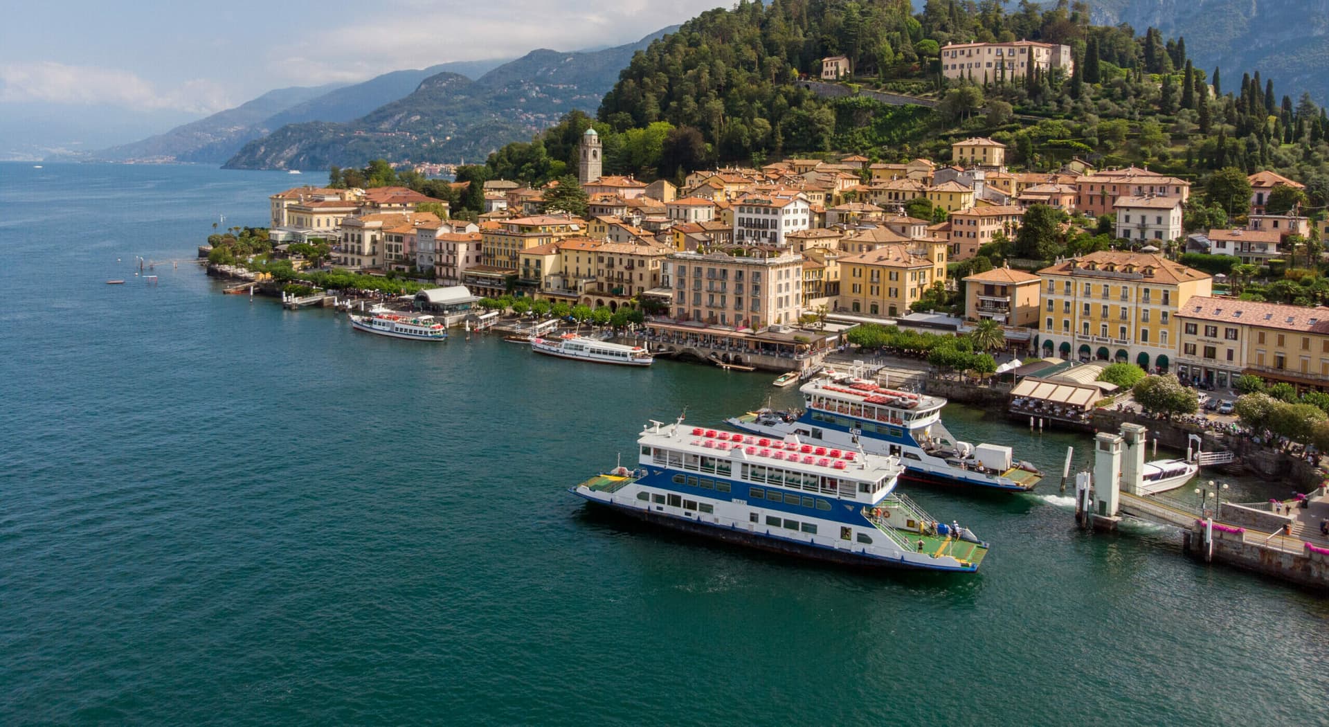 Ferry arriving at Bellagio's dock with colourful village facades in the background