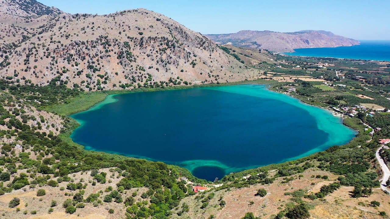 The turquoise waters of Lake Kournas with green hills in the background