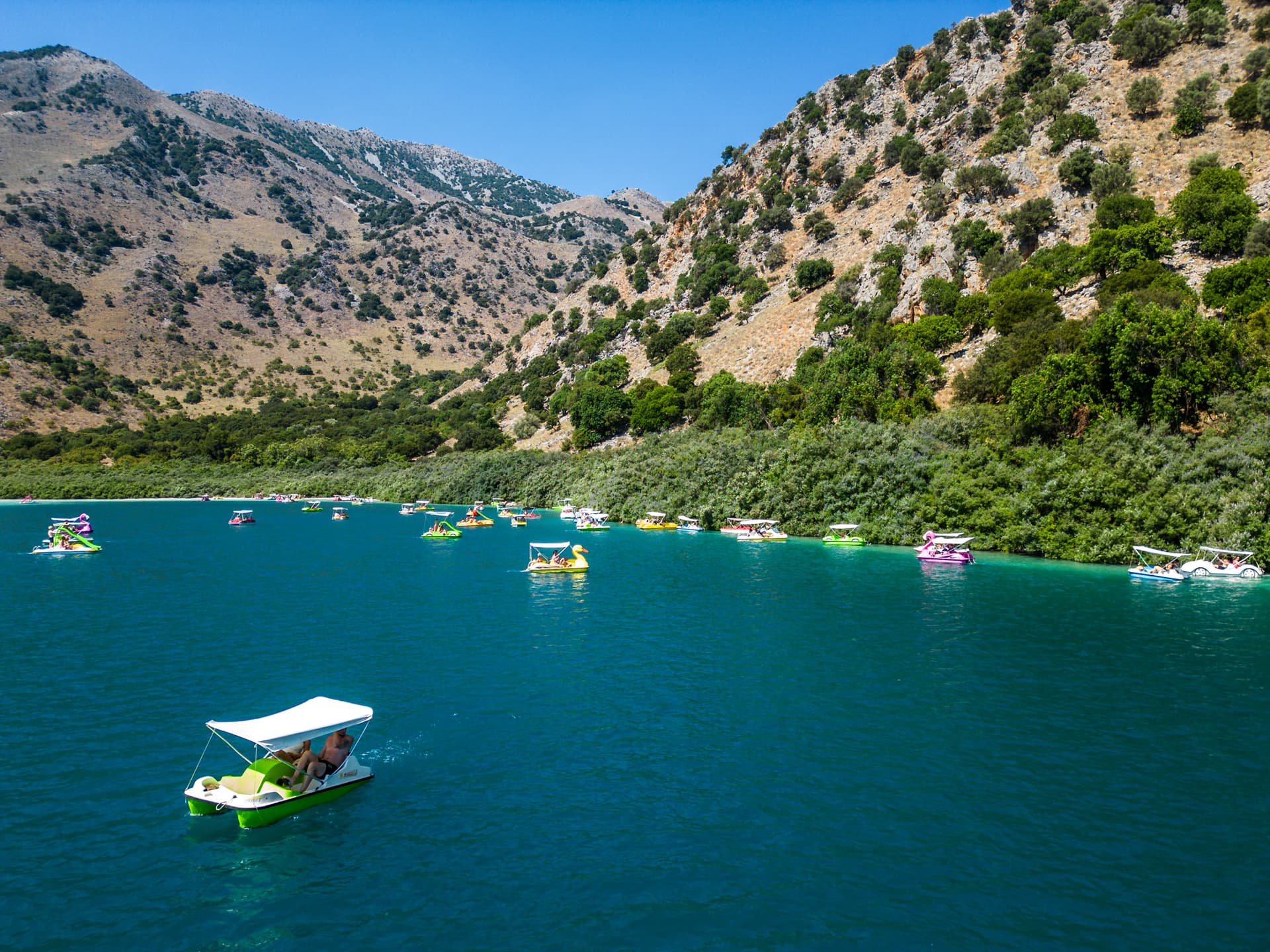 Colourful pedalos on the blue-turquoise waters of Lake Kournas in Crete