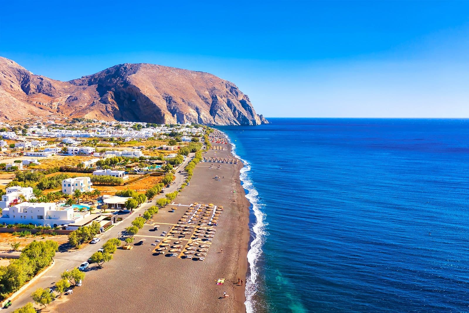 Plage de Perissa à Santorin avec sable noir volcanique et la montagne Mesa Vouno en arrière-plan