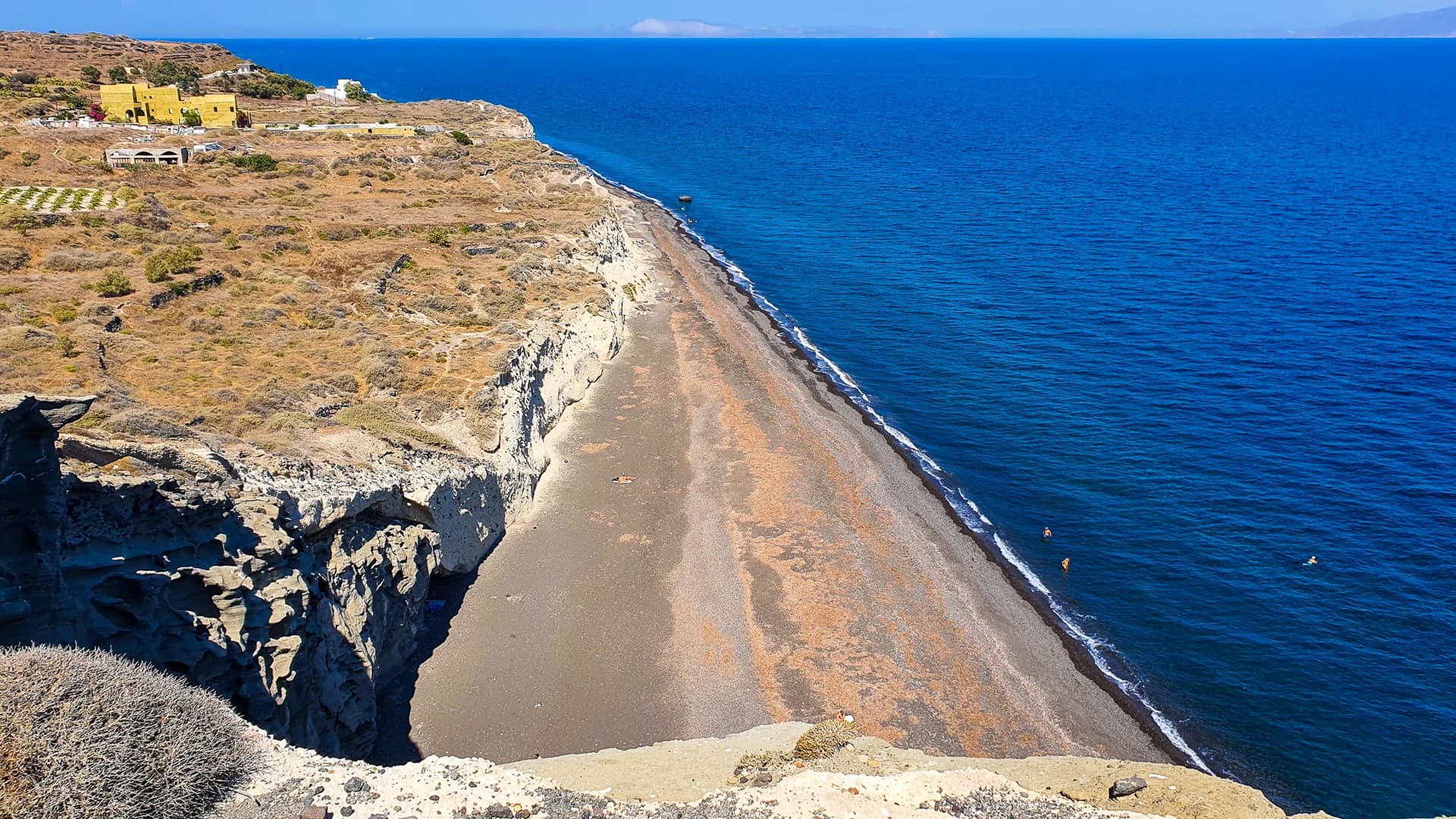 Plage sauvage de Koloumbos à Santorin, déserte avec sable noir et falaises