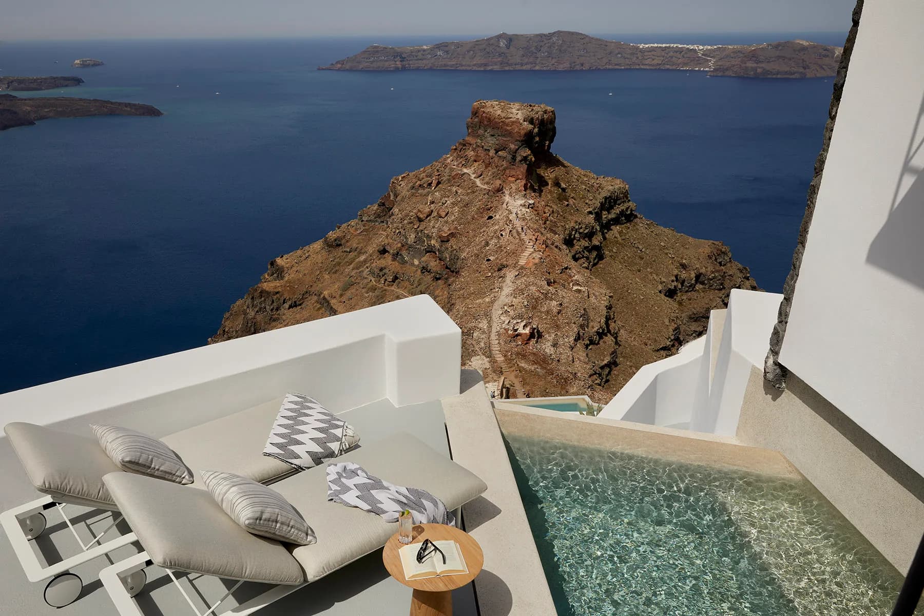 Suite du Grace Hotel avec terrasse privée et piscine face à la caldeira