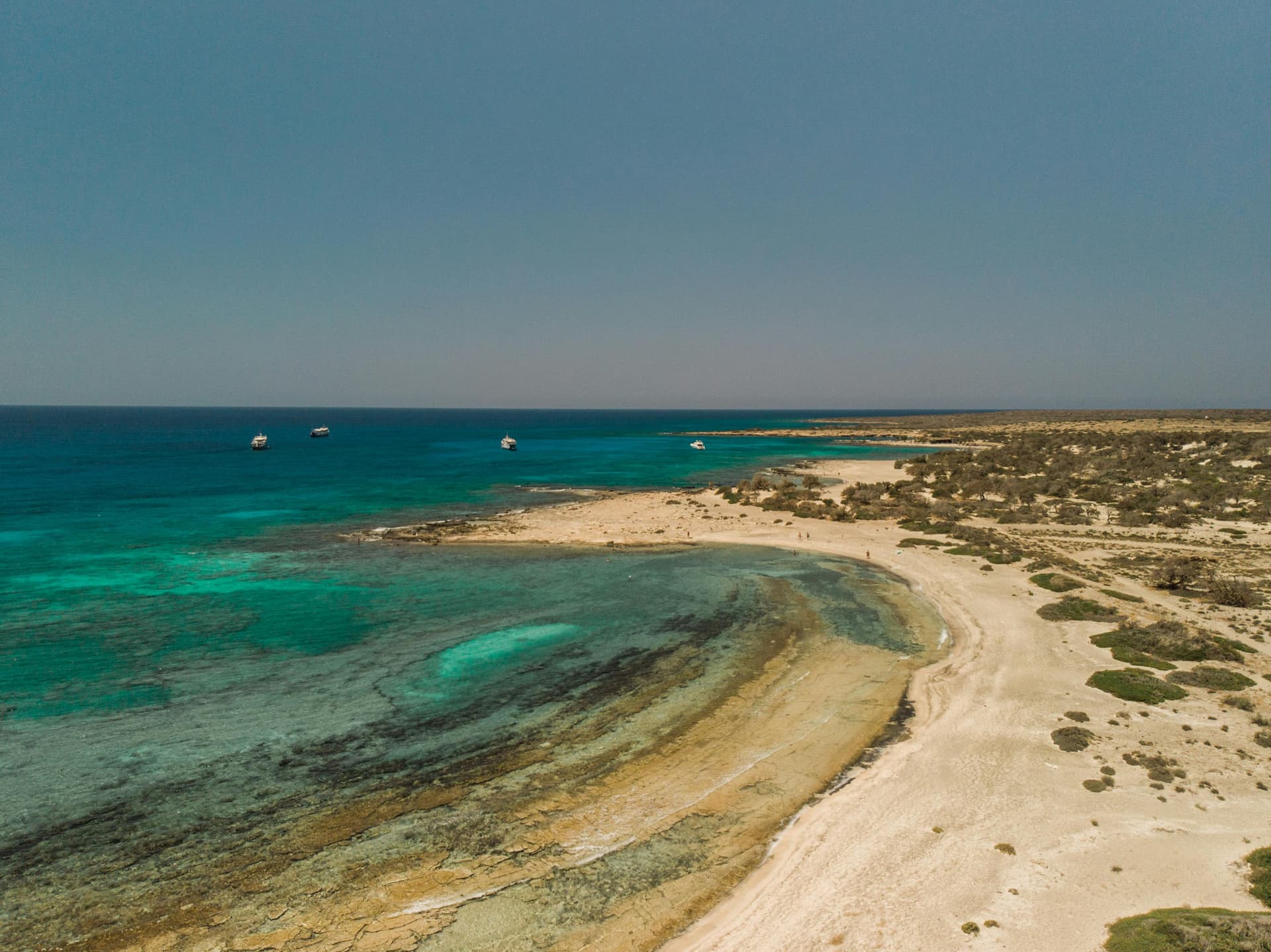 Plage sauvage de Crète à l'aube avec sable clair et eau turquoise
