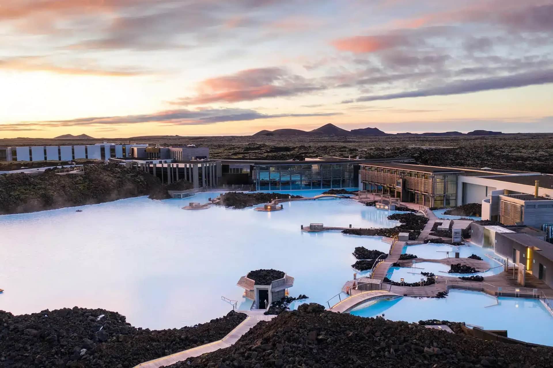 Turquoise waters of the Blue Lagoon in Iceland surrounded by black volcanic rocks and steam