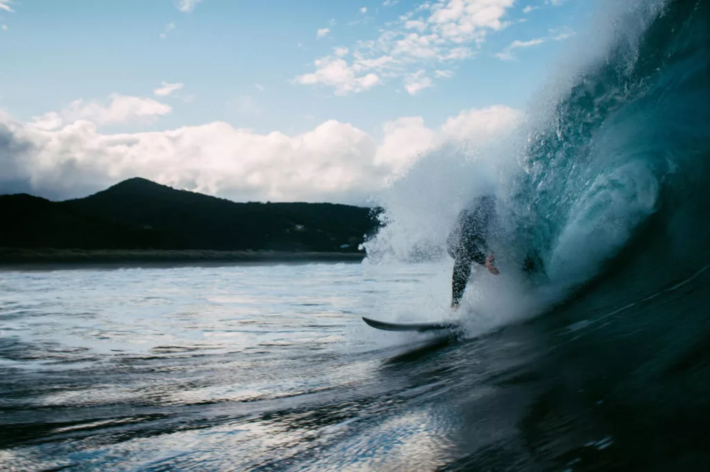 Surfez les impressionnantes vagues de Piha Beach